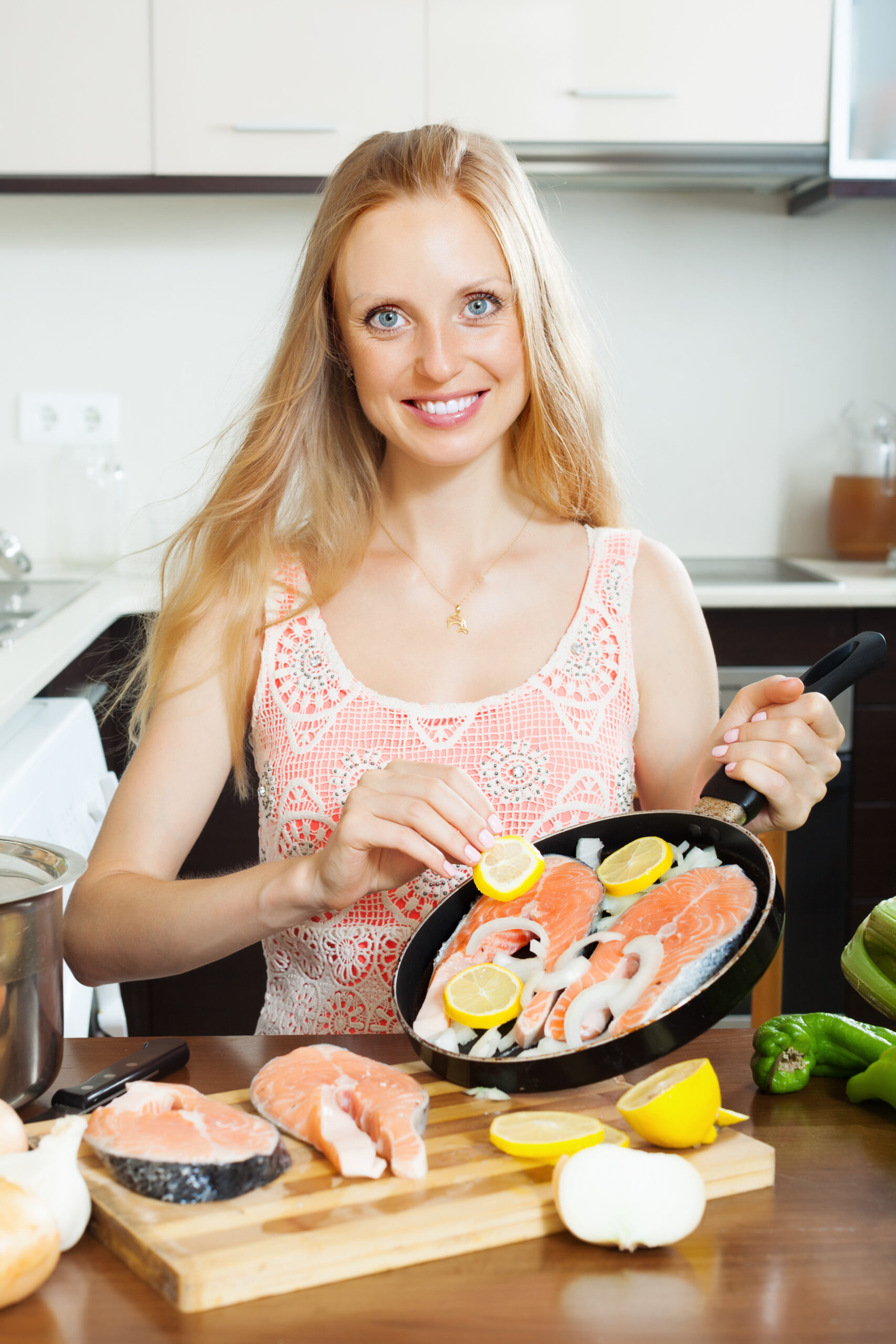 woman cooking salmon with lemon 1 scaled